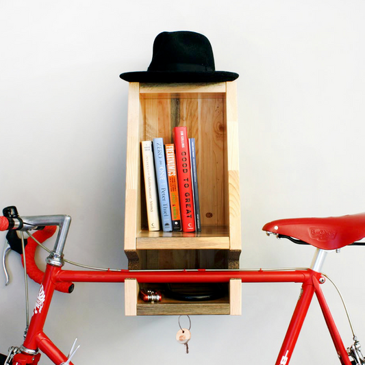 Wooden shelf holding to a red bicycle with books.